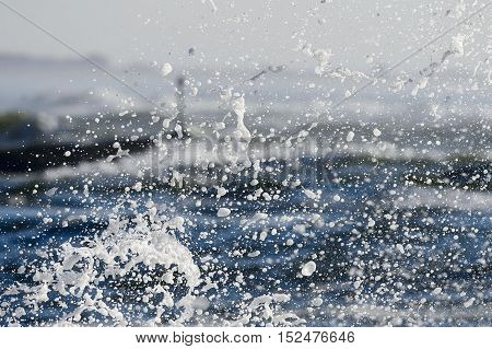 Wave exploding against rock turns to foam