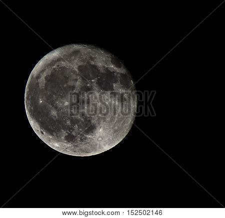 silvery full moon in the black sky and the dark