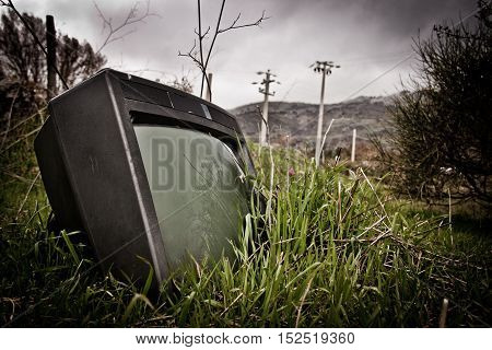 an old abonded tv lying in the gras
