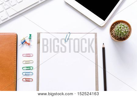 Office desk top view with smartphones, laptop and book / Office supplies Blank and pencil notebook and earphones on white background.