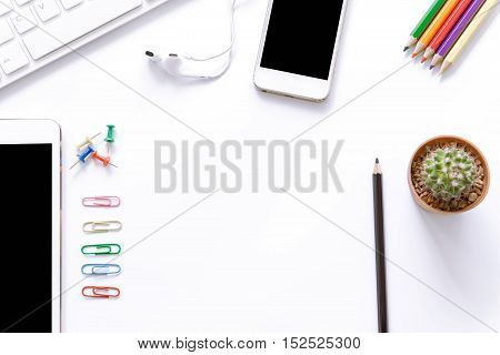 Office desk top view with smartphones, laptop and book / Office supplies Blank and pencil notebook and earphones on white background with copy space