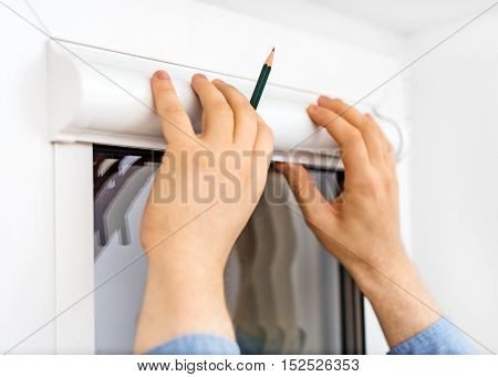 Man Installing Cassette Roller Blinds On Windows.