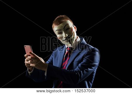 London - UK - 19 October 2016 - Businessman wearing a hacker mask. This mask is a well-known symbol for the online hacktivist group Anonymous