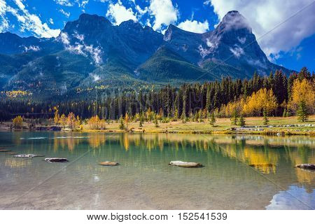 Shining day in Canmore. The famous Three Sisters mountains in the Canadian Rockies. Concept of hiking
