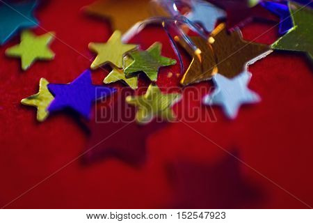 small multi-colored stars on a red background