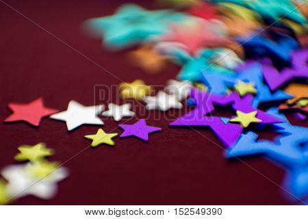 small multi-colored stars on a red background