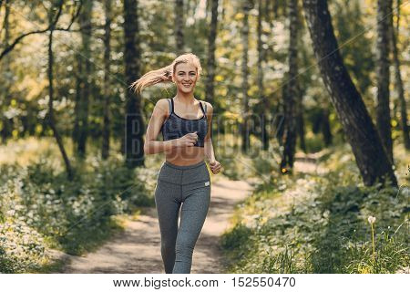 athletic girl running in the Park and doing exercises Jogging