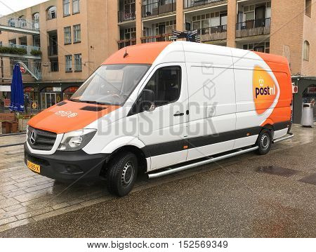 Almere Stad, Flevoland, The Netherlands - October 20, 2016: PostNL van by the side of the road in the city of Almere. nobody in the vehicle.