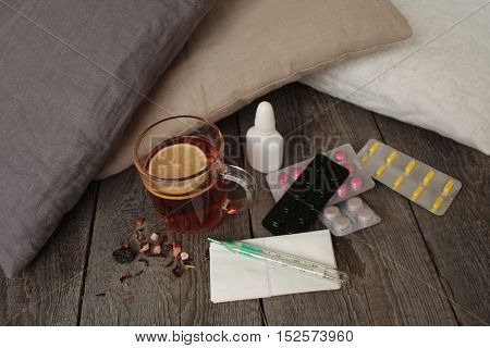 pills, thermometer, medical tea with lemon. a cold or sickness in the winter or fall.