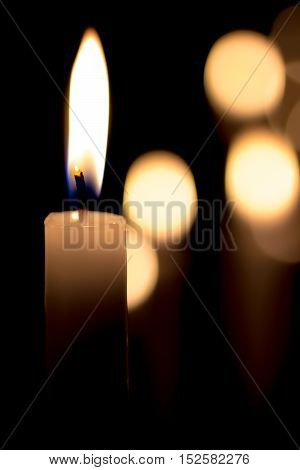 closeup of a burning candle on a dark background with soft lighting
