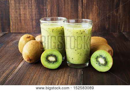 Kiwi green smoothie in glass on wooden background selective focus toned horizontal