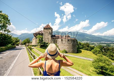 Vaduz, Liechtenstein - July 01, 2016: Young female tourist visits Vaduz castle in the capital of Liechtenstein. This castle is the palace and official residence of the Prince of Liechtenstein