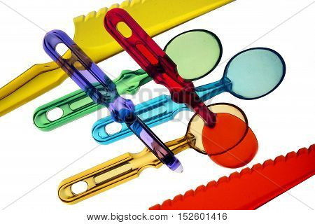 Transparent plastic spoons and knives on a white background, macro . Disposable cutlery