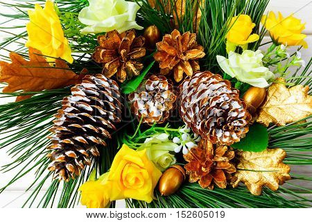 Christmas background with golden decorated pine cones and silk roses. Christmas party decoration top view.