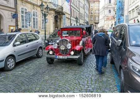 PRAGUE, OCTOBER 15: Old historic red car Praga on Mostovska street on October 15, 2016 in Prague, Czech Republic. Old cars are in Prague for tourists on tours of the city.