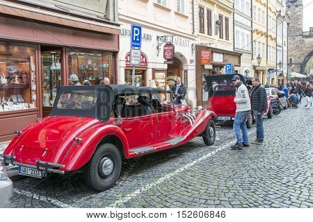 PRAGUE, OCTOBER 15: Old historic red car Praga on Mostovska street on October 15, 2016 in Prague, Czech Republic. Old cars are in Prague for tourists on tours of the city.