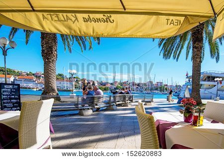 TROGIR CROATIA - SEPTEMBER 17: Croatian restaurant by the seafront in Trogir town with a view of the harbor and promenade on a sunny day on September 17 2016 in Trogir