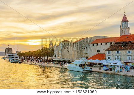 TROGIR CROATIA - SEPTEMBER 18: This is Trogir a UNESCO world heritage site. This photograph shows the waterfront promenade area with tourists boats and sunset on September 18 2016 in Trogir
