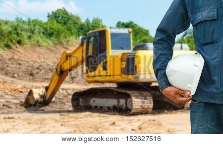 The engineering and safety helmets stood on the details of Closeup skid steer loader excavator at road construction work