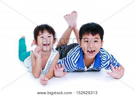 Asian kids lying prone on the floor. Chinese children having happy and smiling isolated on white background. Conceptual about loving of sibling. Happy family spending time together. Studio shot.