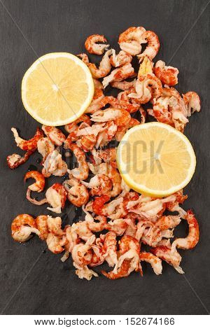 cleaned and cooked crayfish tails with lemon slice on slate