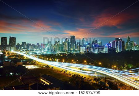 Abstract and car lighttrail background city skyline downtown background and highway interchanged nigh view .