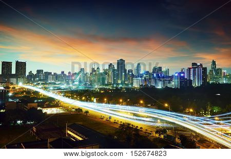 Abstract and car lighttrail background city skyline downtown background and highway interchanged nigh view .
