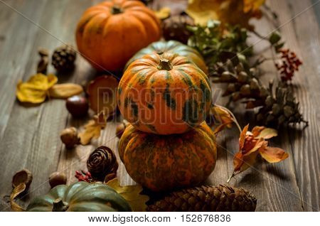 Autumn decorative pumpkins, fall leaves on a rustic wooden background, natural fall style decorations. Natural plenteous border background vintage mock up.