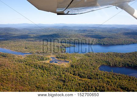 Adirondack forests, lakes, creeks and mountains aerial terrain view down from light aircraft