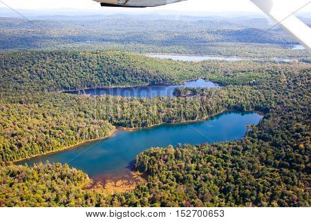 Adirondack forests, lakes, creeks and mountains aerial terrain view down from light aircraft