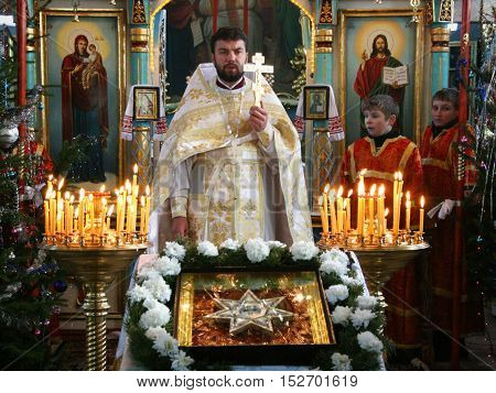 VOYUTYN UKRAINE - 08 JANUARY 2009: Orthodox priest and little sextons during holiday prayers