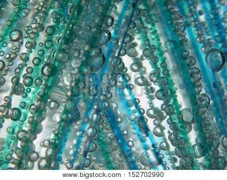 underwater photo, shiny water droplets, green blue bands objects in the water, air bubbles on the surface