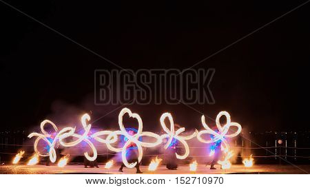 Artists juggling with burning poi's at fire performance. Long exposure causing painting with light.