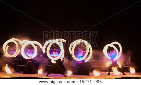 Artists juggling with burning poi's at fire performance. Long exposure causing painting with light.