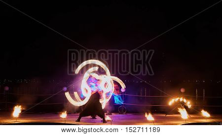 Artists juggling with burning poi's at fire performance. Long exposure causing painting with light.