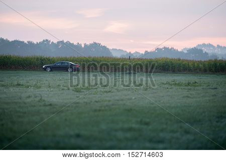 Car driving through rural misty landscape. Geesteren. Gelderland. The Netherlands.