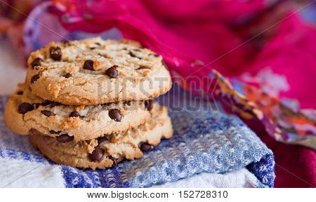 Oatmeal cookies with chocolate chips stacked on a white blue pink background. Selective focus