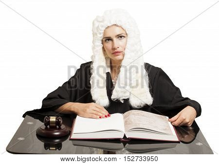 Female judge wearing a wig and black mantle with judge gavel and book isolated on white background