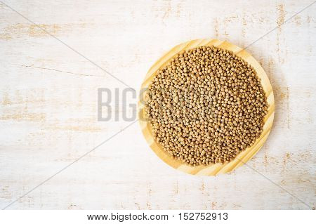 Giant wholegrain couscous on wooden plate on white table horizontal selective focus