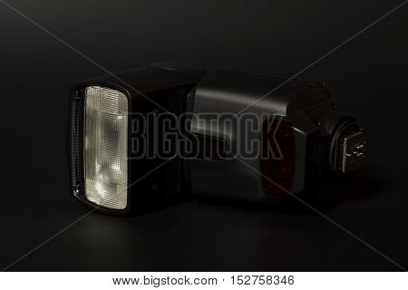 Camera flash speedlight on a black background