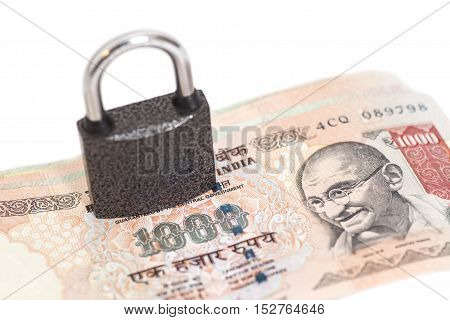 Padlock on Indian currency rupee isolated on white