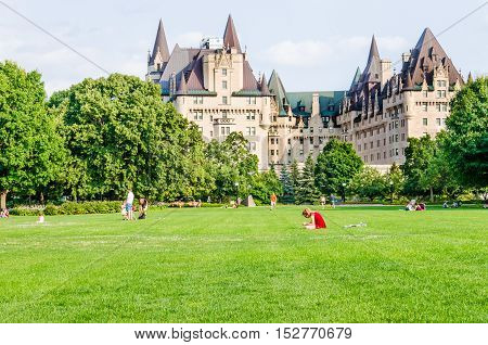 Ottawa, Canada - July 24, 2014: People in Majors Hill Park by Fairmont Château Laurier hotel