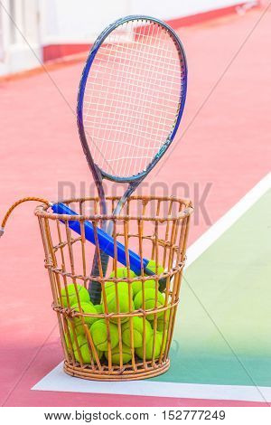 Tennis Ball with Racket on basket tennis court