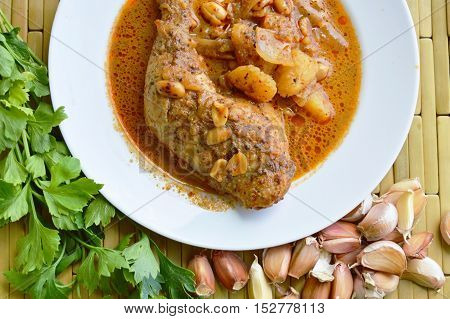 chicken leg Mussaman curry on white dish