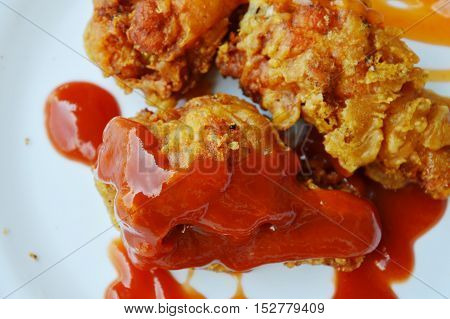 fried chicken leg dressing ketchup and chili sauce on white plate