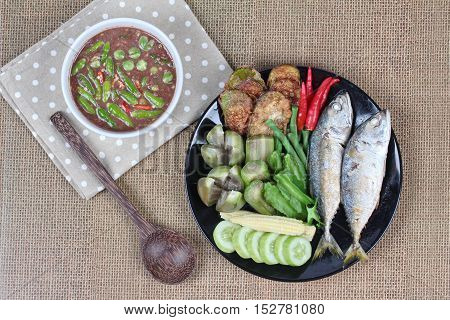 Thai local popular food as spicy shrimp paste dip (Nam Prik Kapi in Thai) served with side dish as deep fired mackarels,boiled long-eggplant,lentils,winged bean ,red hot chili pepper and cucumber.