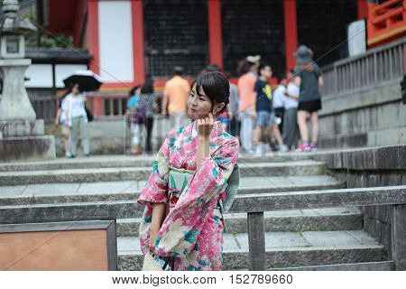 Kyoto,Japan-June 26,Women's kimonos post and smile for photo within Fushimi Inari shrine on June 26,2016 in Kyoto,Japan. Selective focus at wowan.