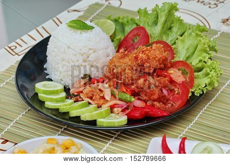 Close up of jasmine rice with spicy fried chicken salad (Khao Yum Kai Zap in Thai). Selective focus.