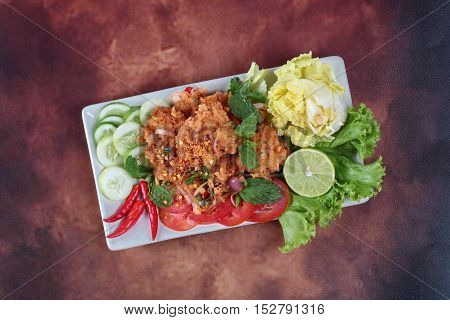 Spicy fried chicken salad (Yum Kai Zap in Thai) as spicy chicken salad,chili,tomato,red onion,roasted rice,dried chili ,Chinese cabbage,lettuce,peppermint ,cucumber and green lemon juice .