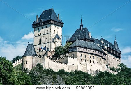 Karlstejn is a large gothic castle founded 1348 by Charles IV in Czech republic. Ancient architecture. Travel destination. Blue photo filter. Beautiful place.
